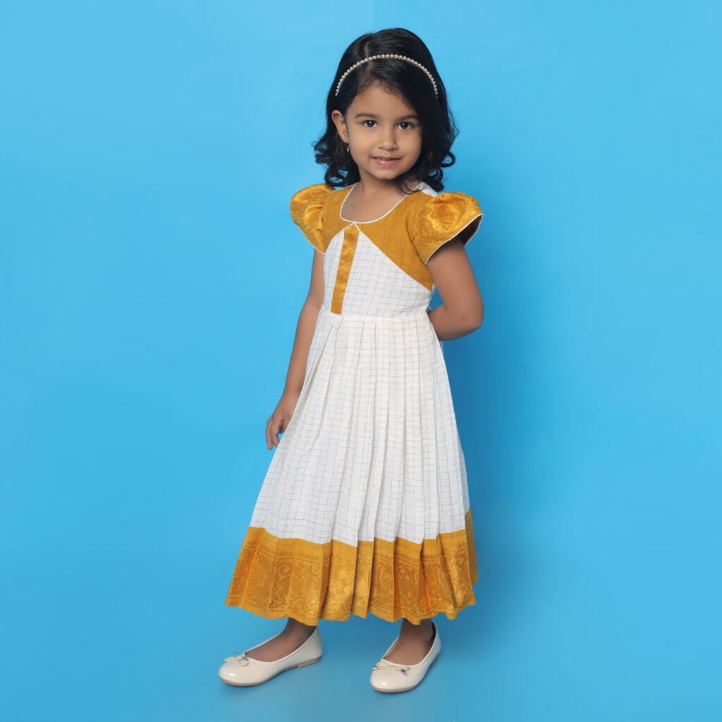Pleated white skirt detail of Amora mustard white kids frock