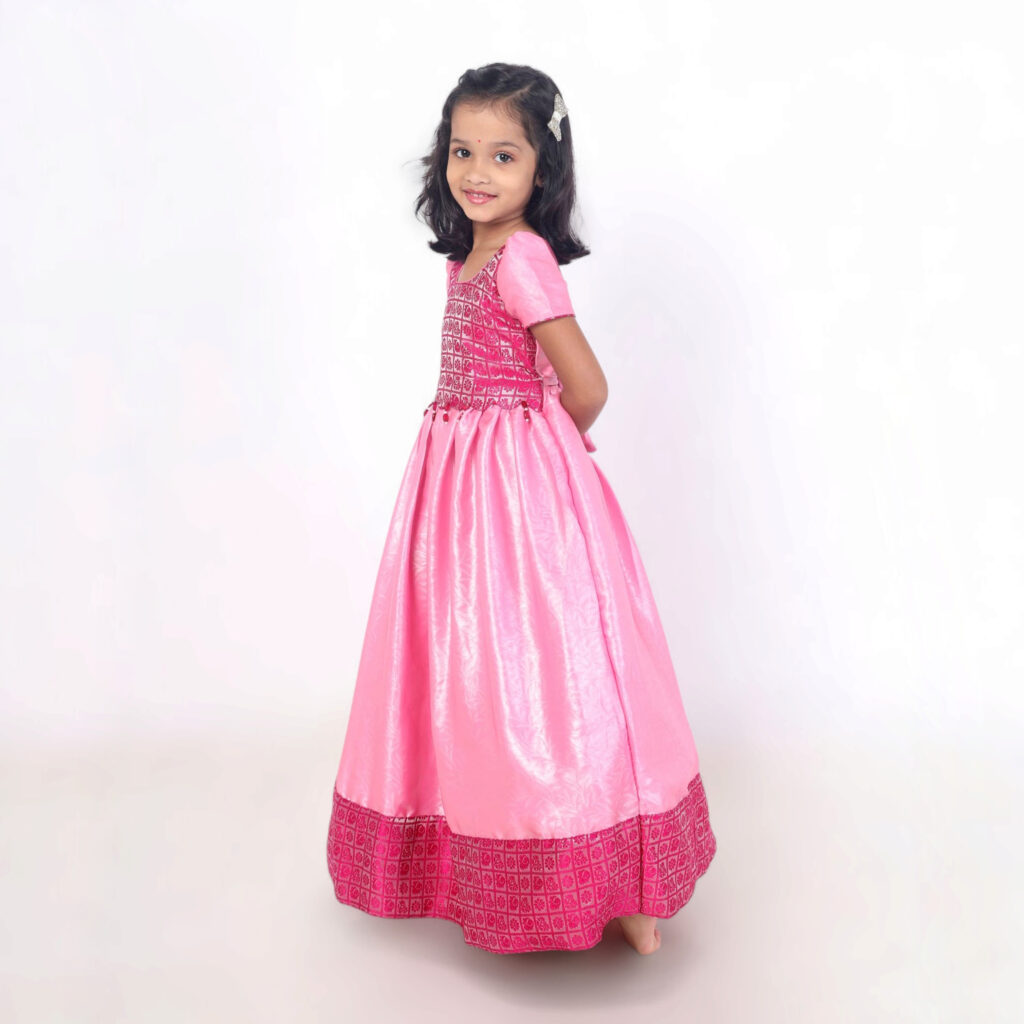 Side view of girls pink long gown with brocade silk bodice and gathered skirt