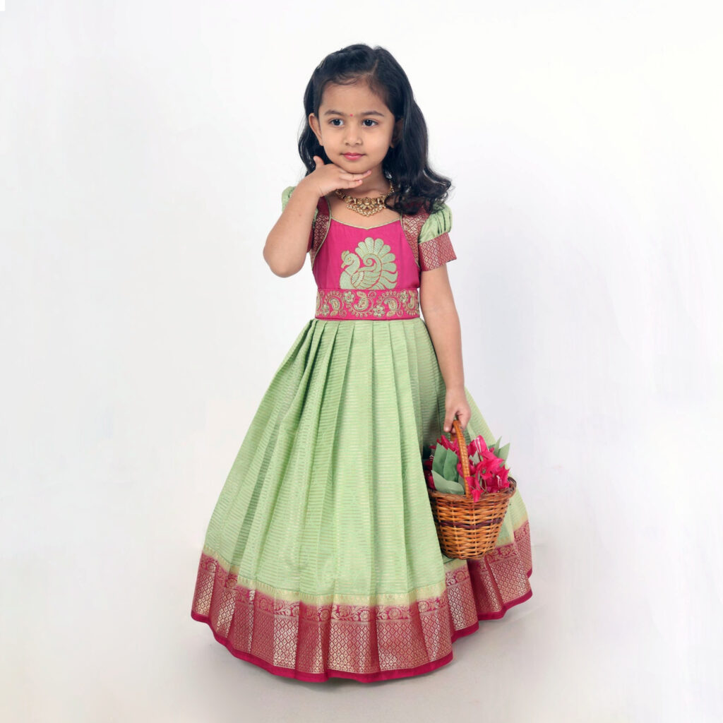Green crepe silk girls festive long gown with pink border and peacock embroidery front view