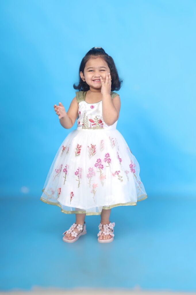 Closeup floral embroidery white net kids frock designer detail