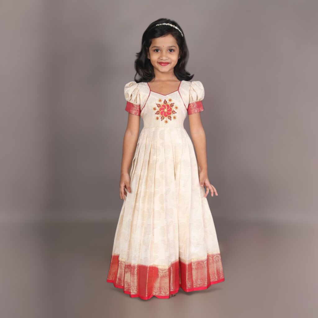 Girls festive long gown in white crepe silk with red border and floral embroidery bodice