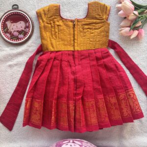 Mustard yellow and red ethnic kids festive frock styled flat lay