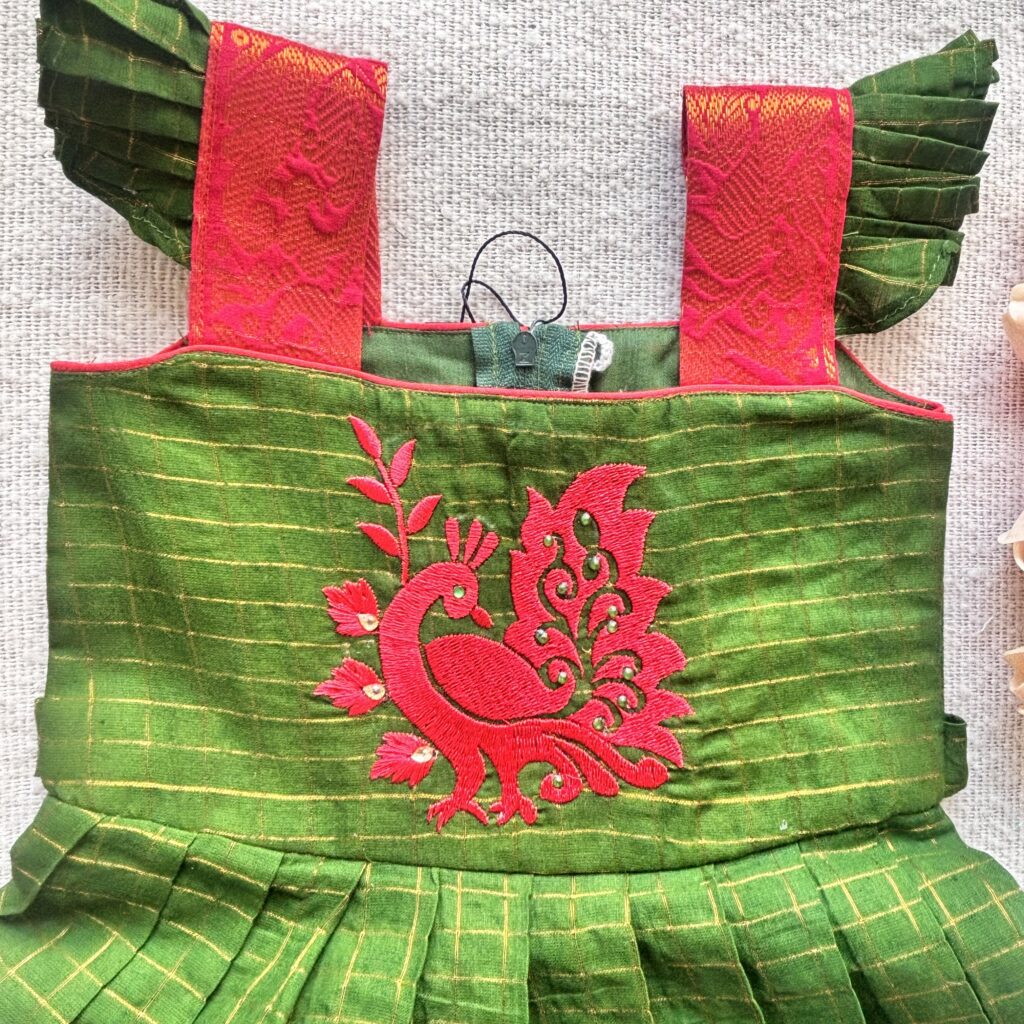 Front view of green Sungudi cotton kids frock with embroidery