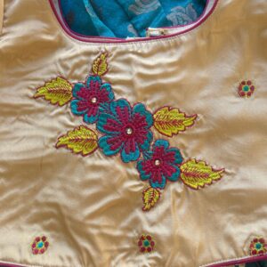 Close up floral embroidery detail on Taara teal skirt and beige crop top