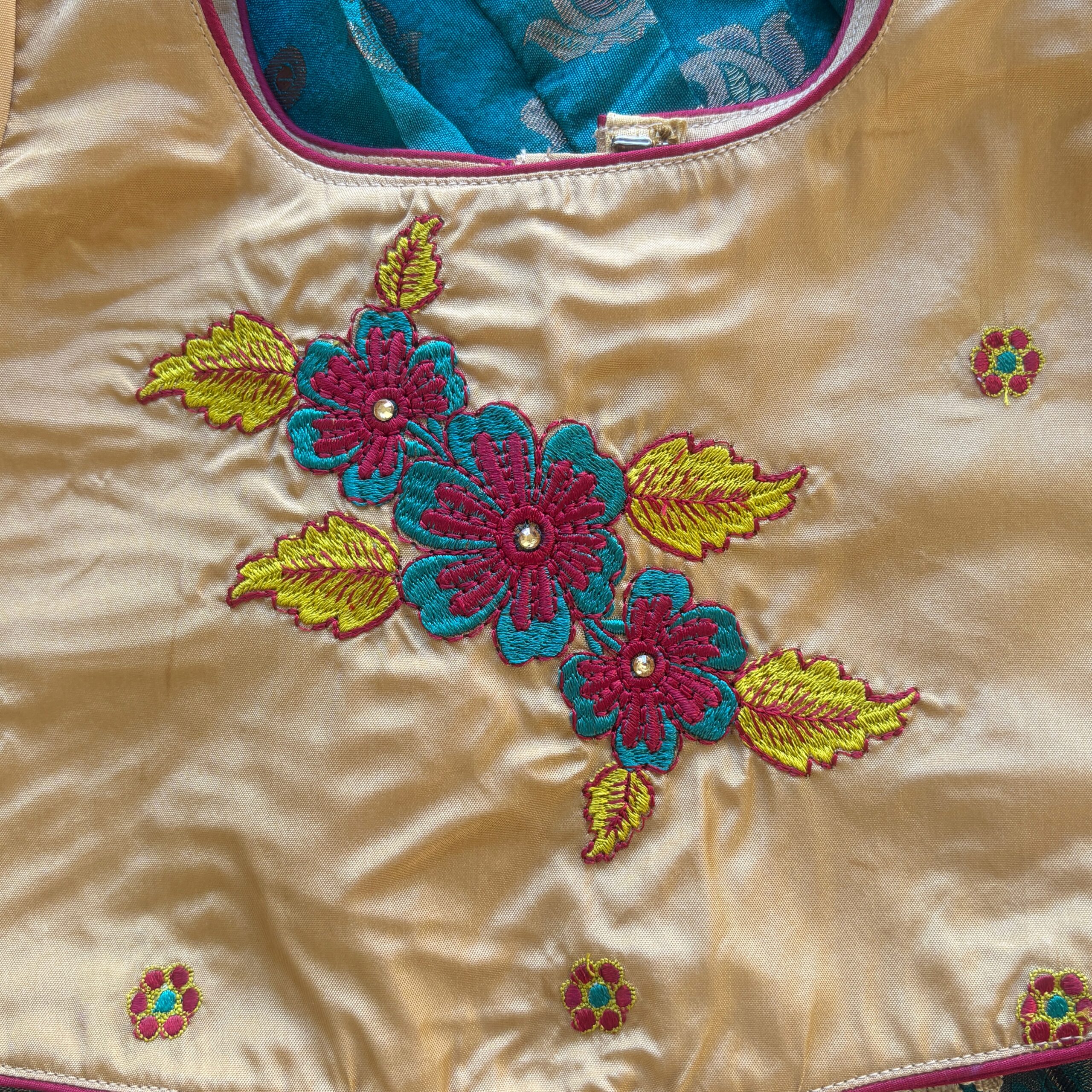 Close up floral embroidery detail on Taara teal skirt and beige crop top