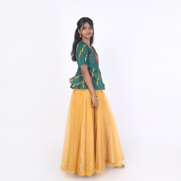 Side profile of mustard net skirt and green embroidered peplum top