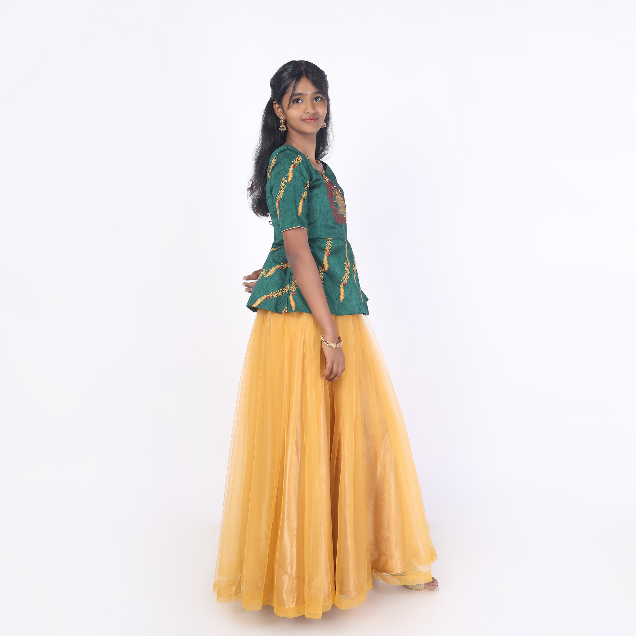 Side profile of mustard net skirt and green embroidered peplum top