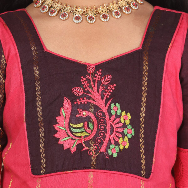 Close up traditional pattern detail on deep brown and pink ethnic long gown
