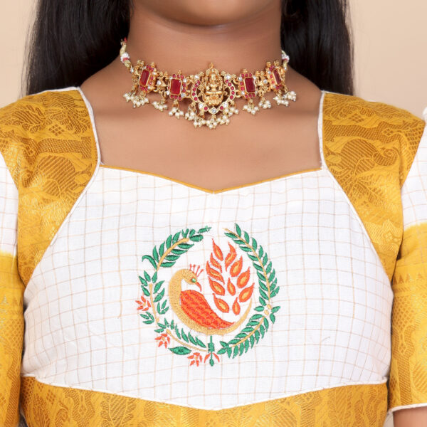 Close up traditional pattern detail on mustard and white ethnic long gown