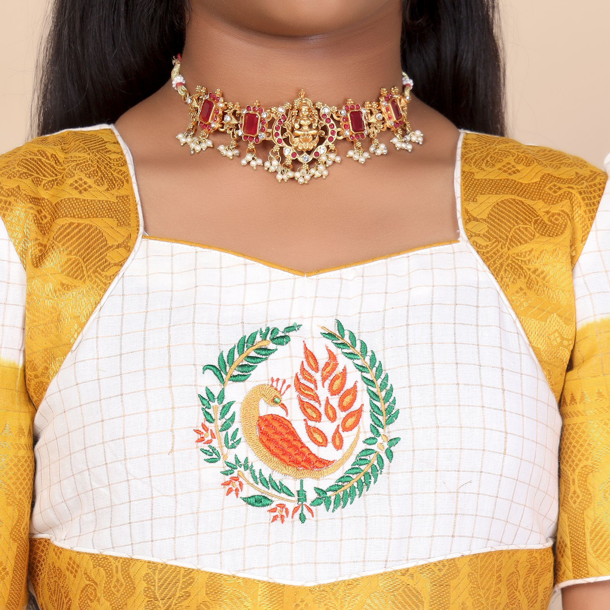 Close up traditional pattern detail on mustard and white ethnic long gown