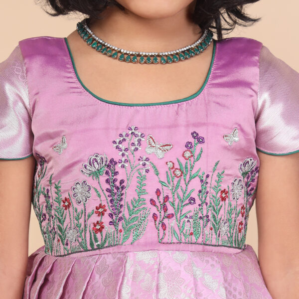 Close up floral garden embroidery on purple kids gown bodice
