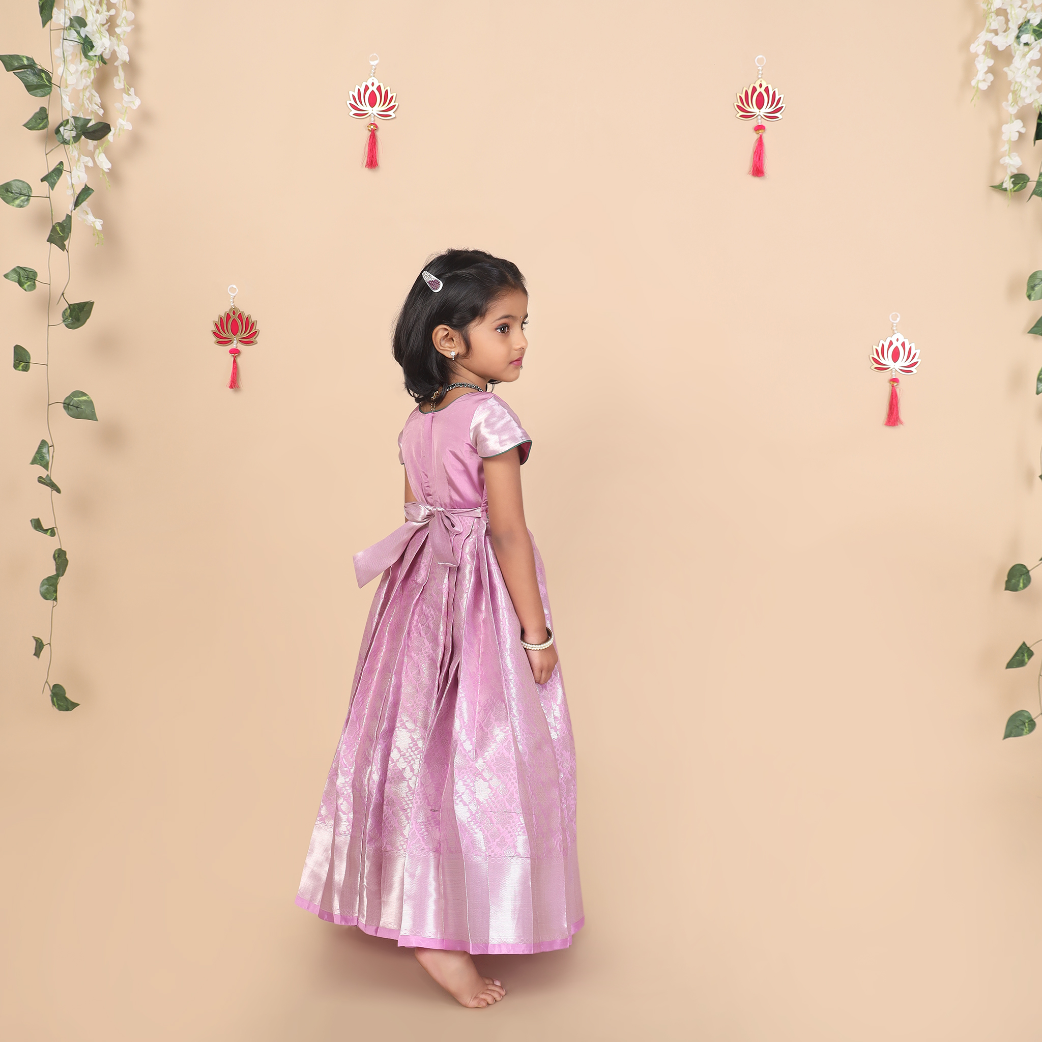 Back view of purple embroidered kids gown with pleated skirt design