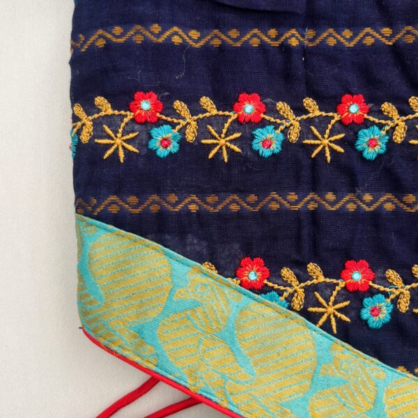 Close up floral embroidery detail on navy blue kids frock