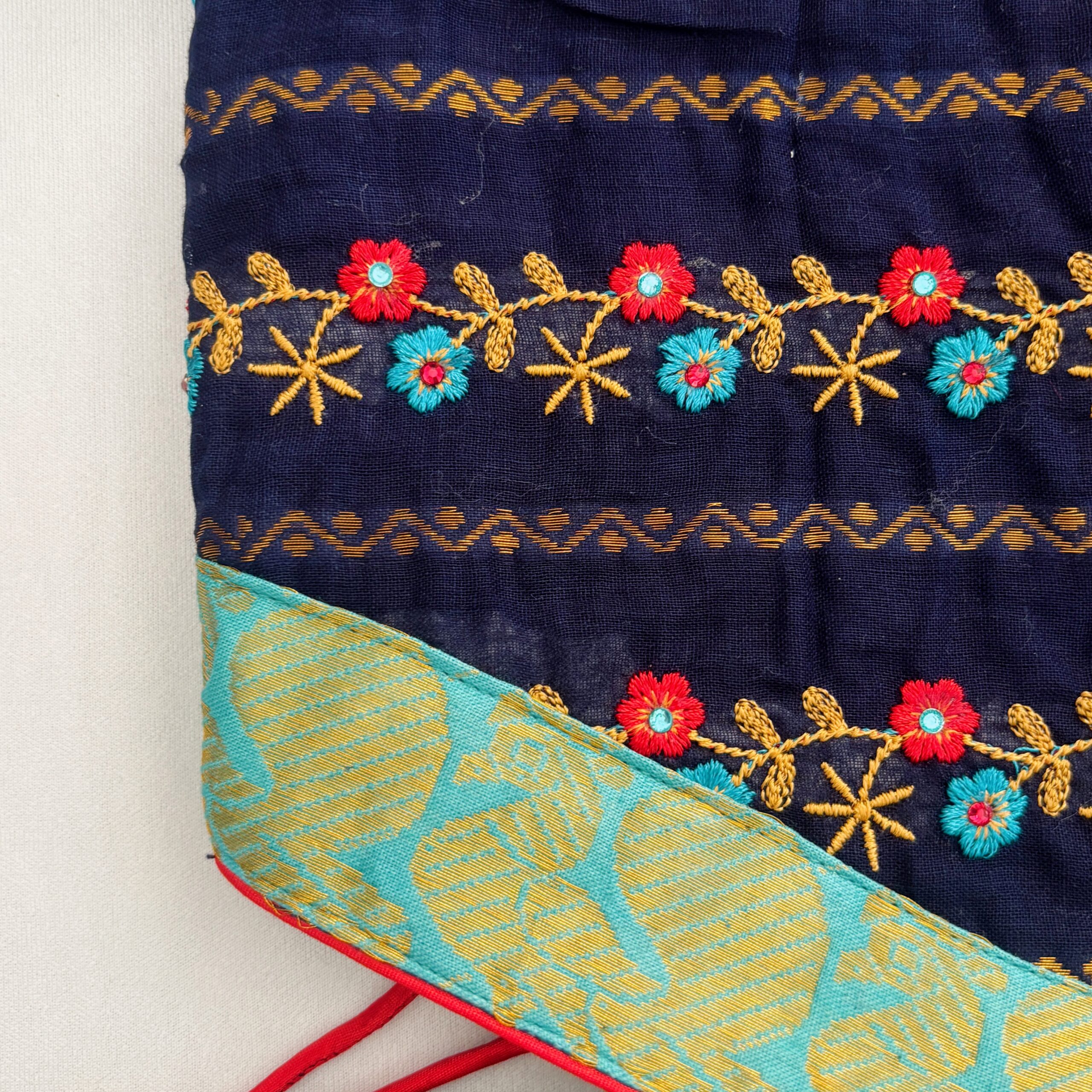 Close up floral embroidery detail on navy blue kids frock