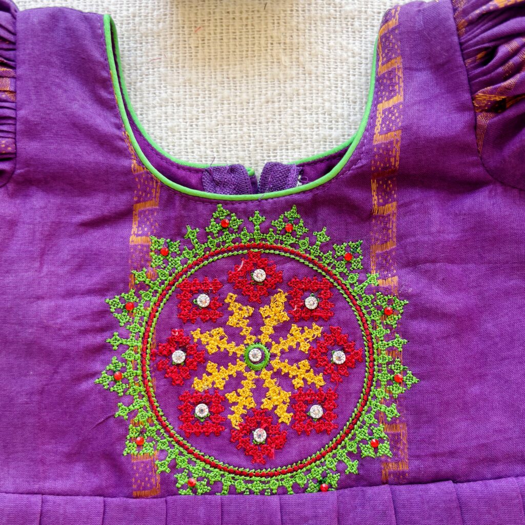 Embroidered bodice design on purple kids frock