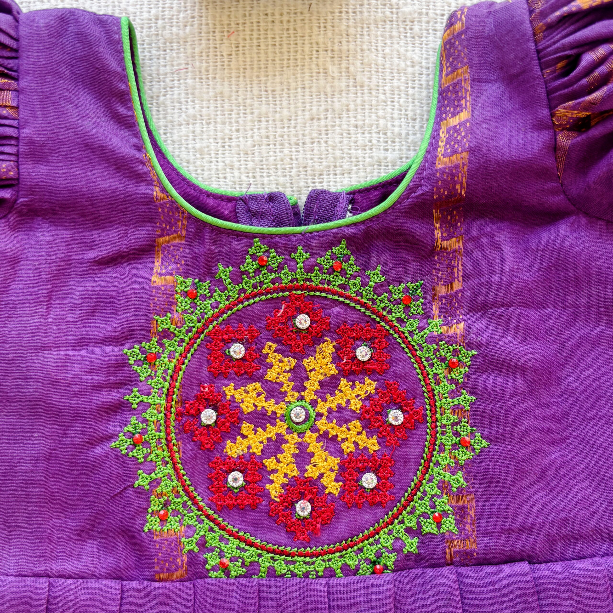 Embroidered bodice design on purple kids frock