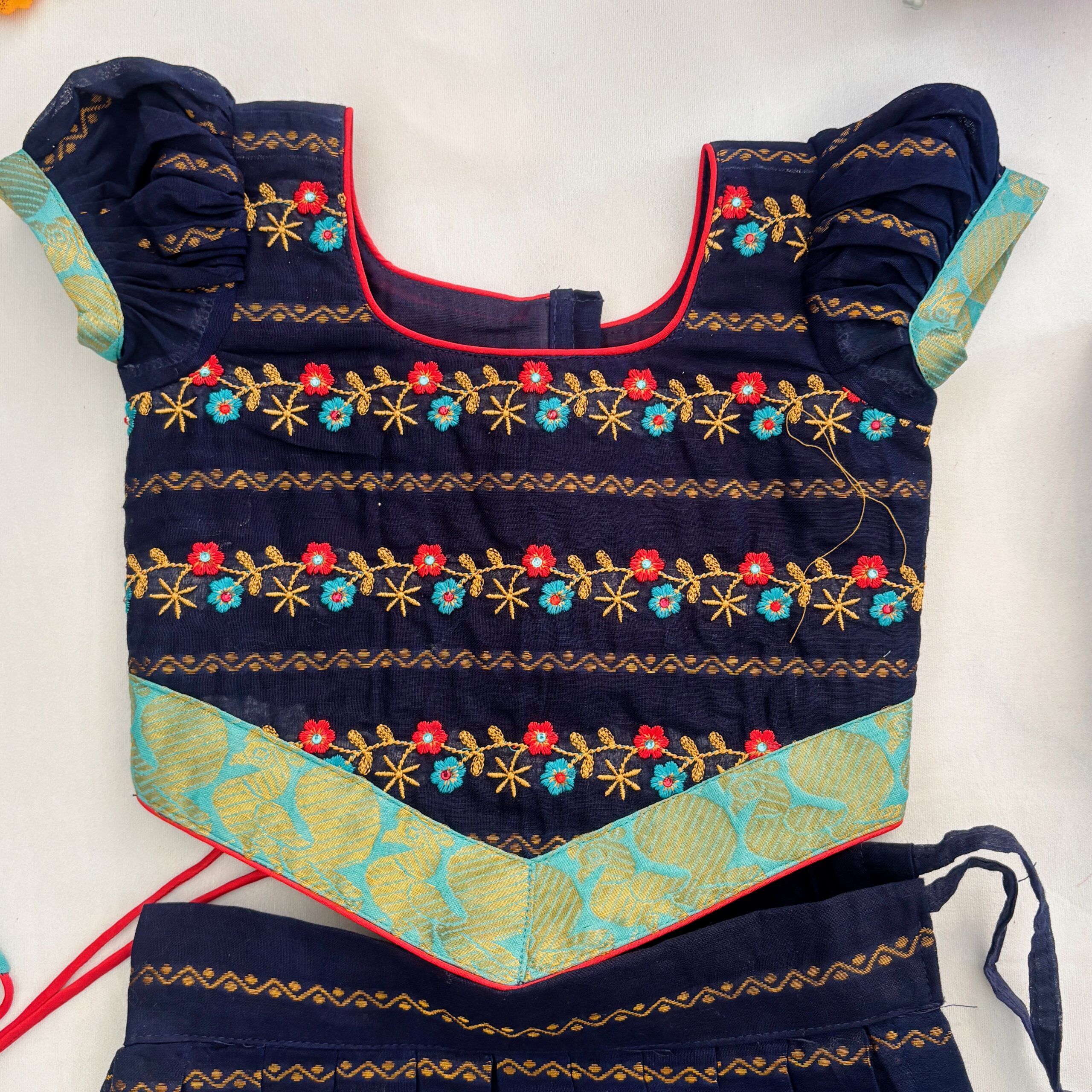 Top view close up of embroidered neckline on navy blue kids frock