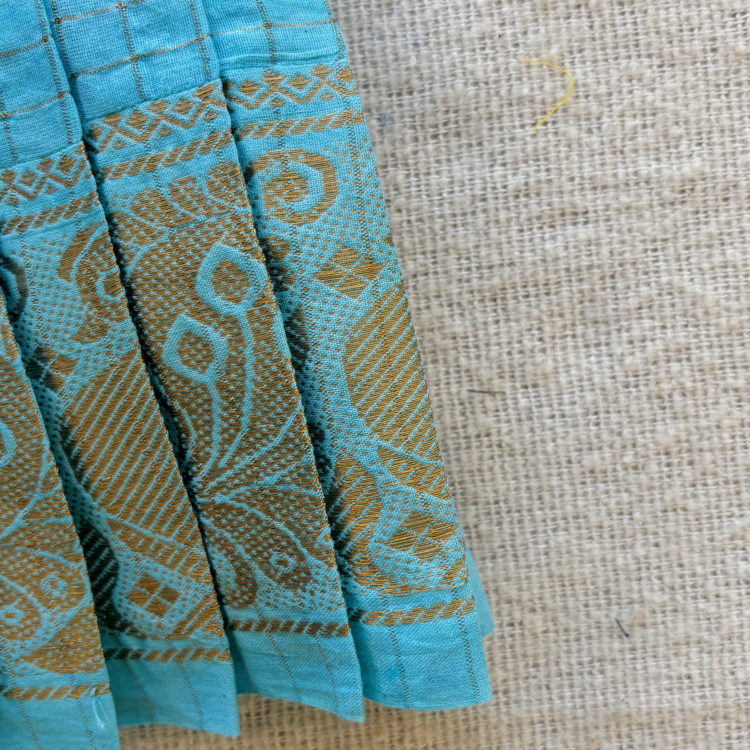 Traditional zari border detail of teal kids frock