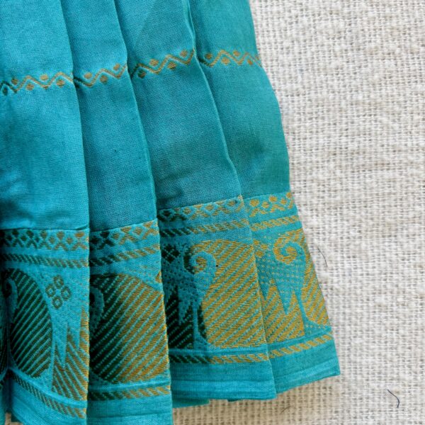 Traditional zari border detail of teal kids frock