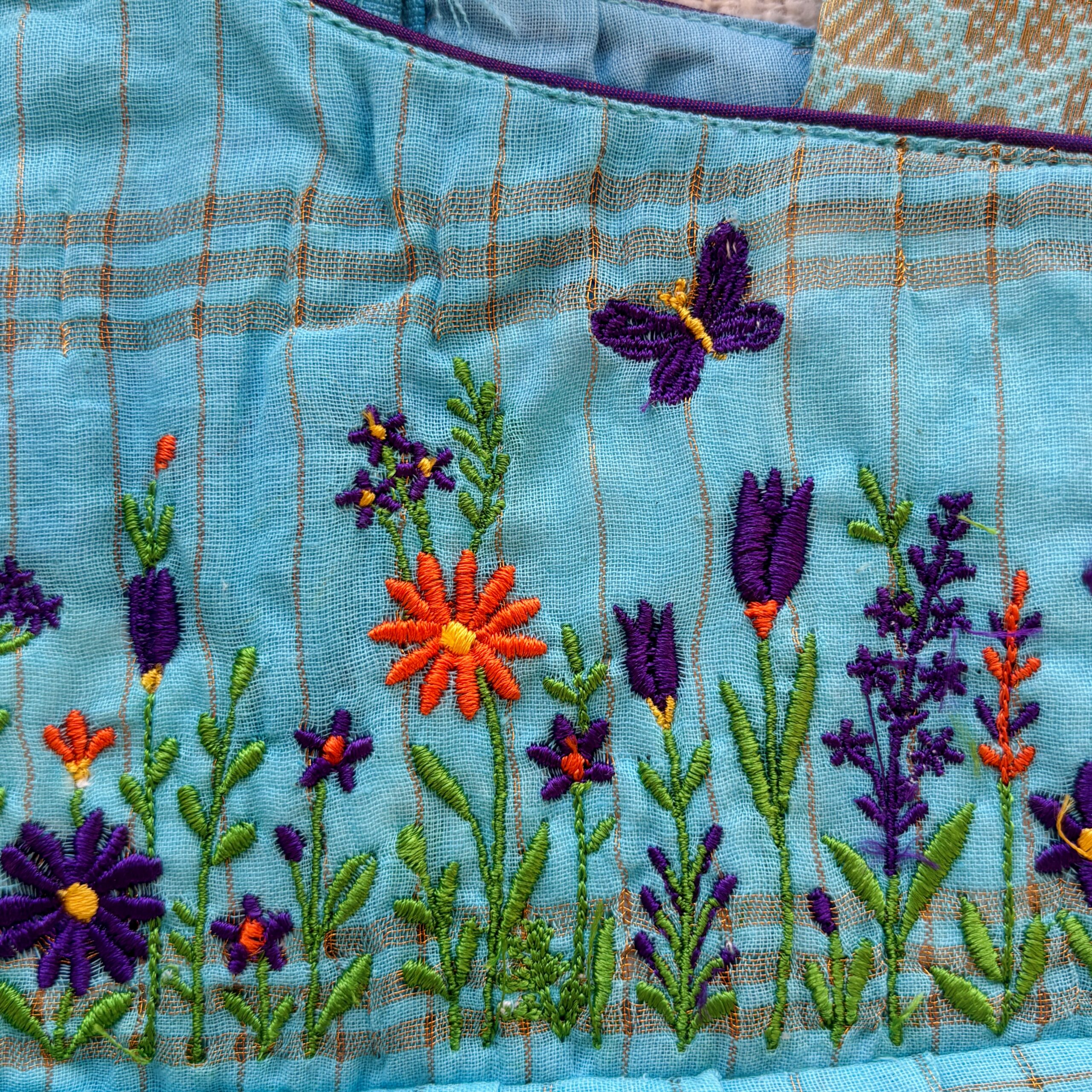 close up Floral embroidery on teal kids frock