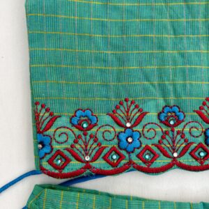 Close up embroidery detail on green kids skirt and top set