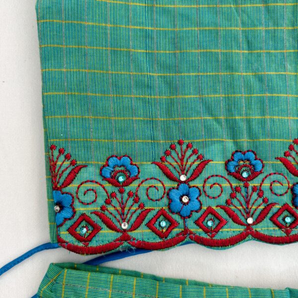 Close up embroidery detail on green kids skirt and top set