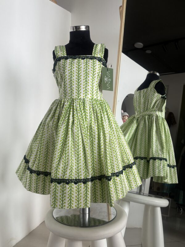 Green cotton girls frock with leafy block print and black lace detailing by Varna Design Wear