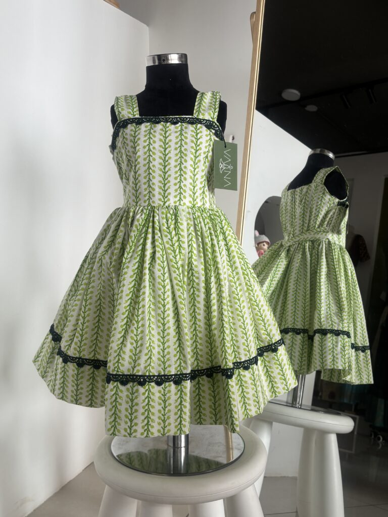 Green cotton girls frock with leafy block print and black lace detailing by Varna Design Wear