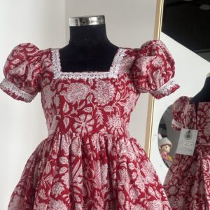 Front view of red floral cotton girls frock with puff sleeves