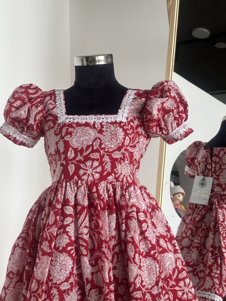 Front view of red floral cotton girls frock with puff sleeves