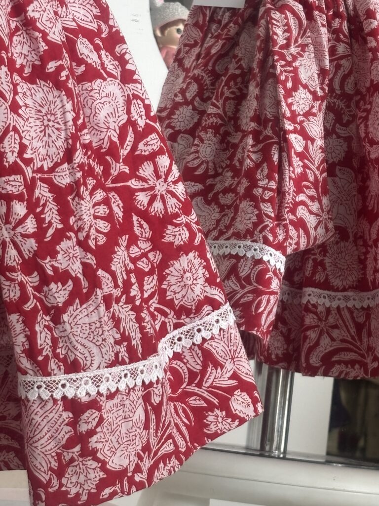 Red cotton girls frock with floral print and white lace border