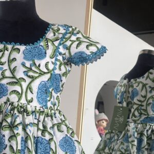 Side view of blue floral cotton girls frock with flutter sleeves