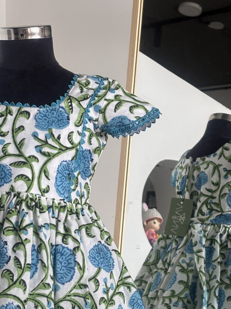 Side view of blue floral cotton girls frock with flutter sleeves
