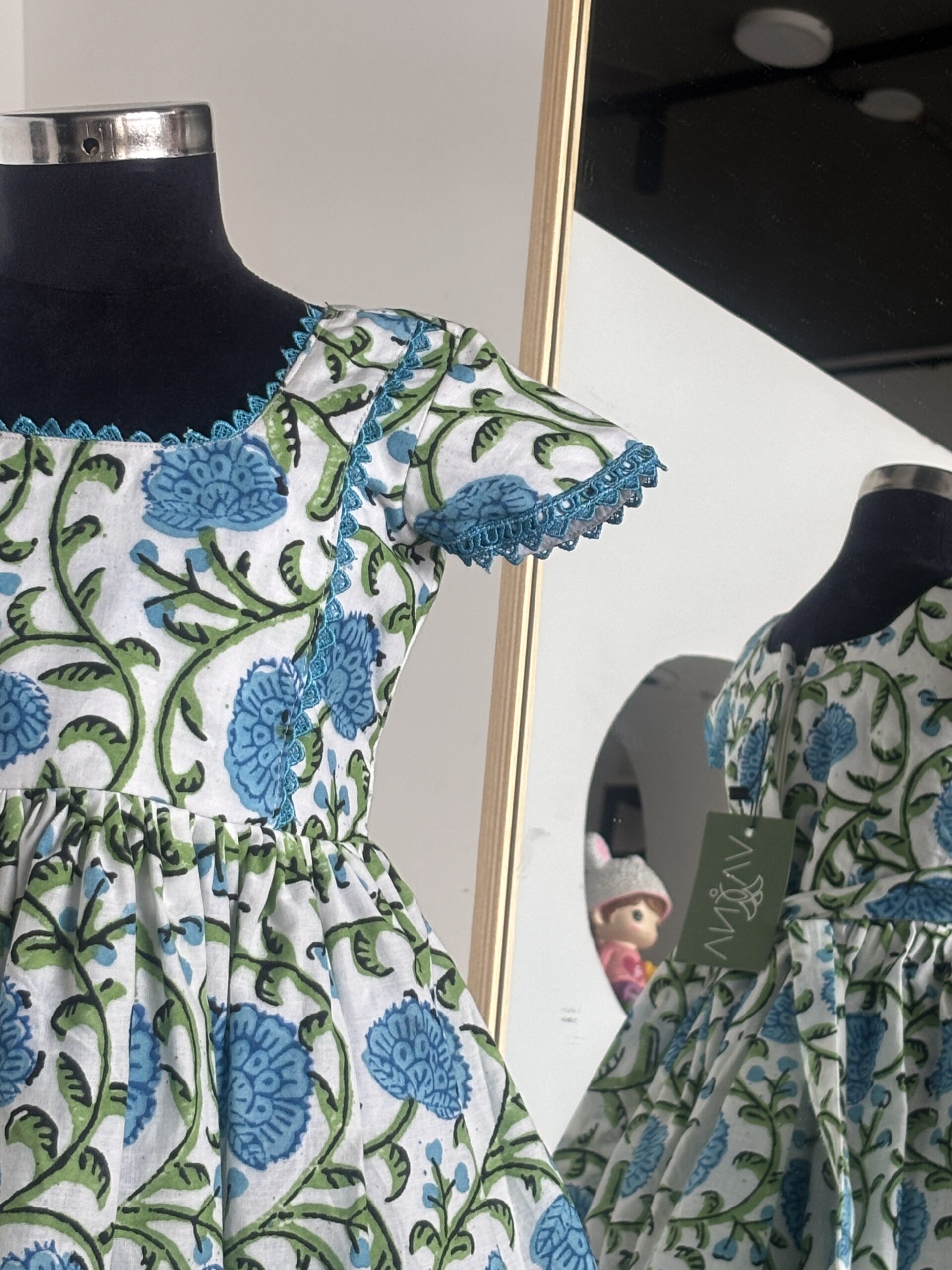 Side view of blue floral cotton girls frock with flutter sleeves