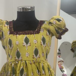Front view of yellow cotton girls frock with gathered skirt