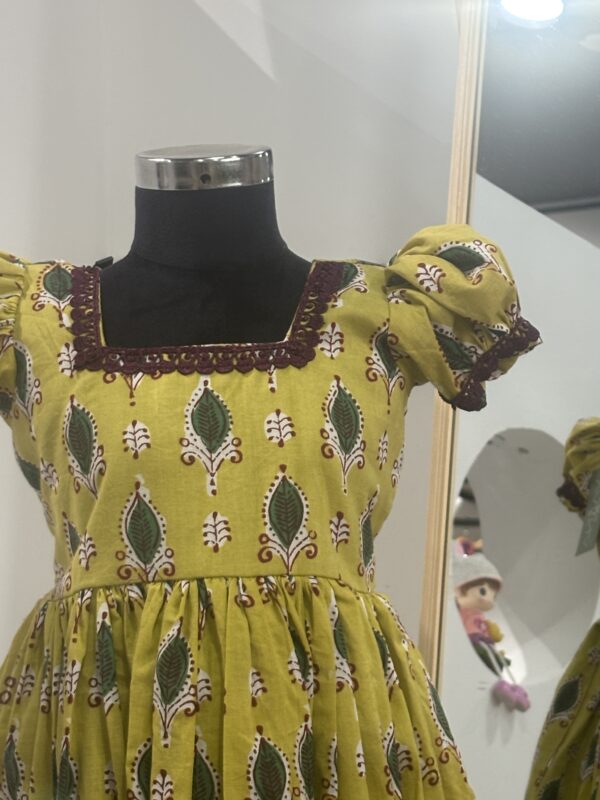 Front view of yellow cotton girls frock with gathered skirt