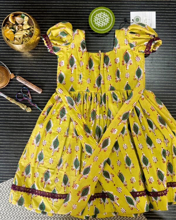 yellow girls frock with puff sleeves and lace border