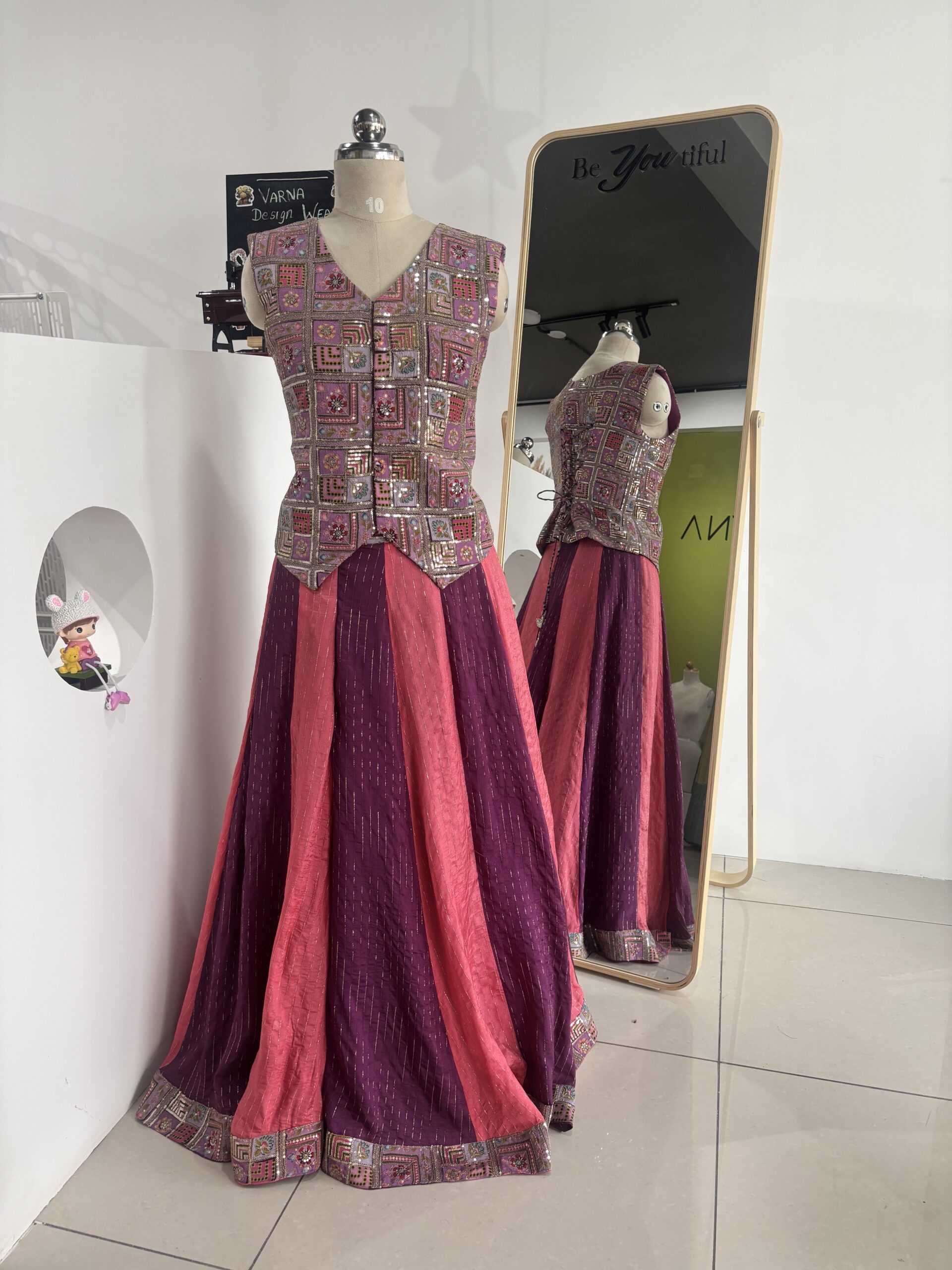 Purple and peach designer panel lehenga with sleeveless jacket style blouse by Varna Design Wear