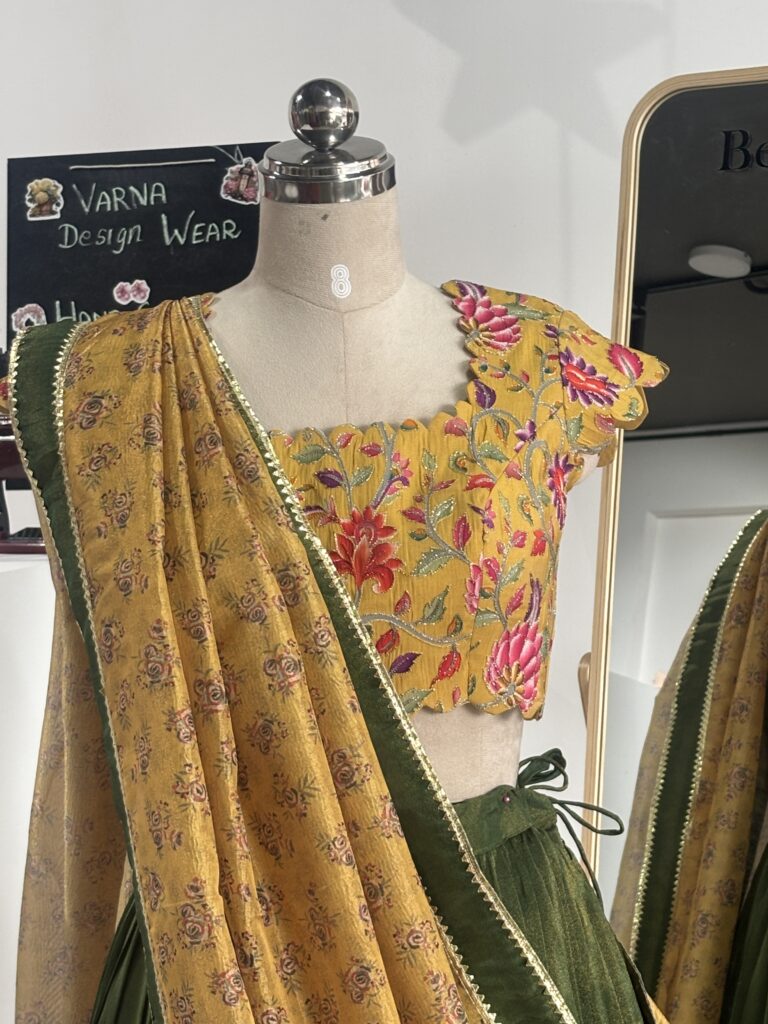 Close-up of floral blouse with olive green lehenga and printed dupatta